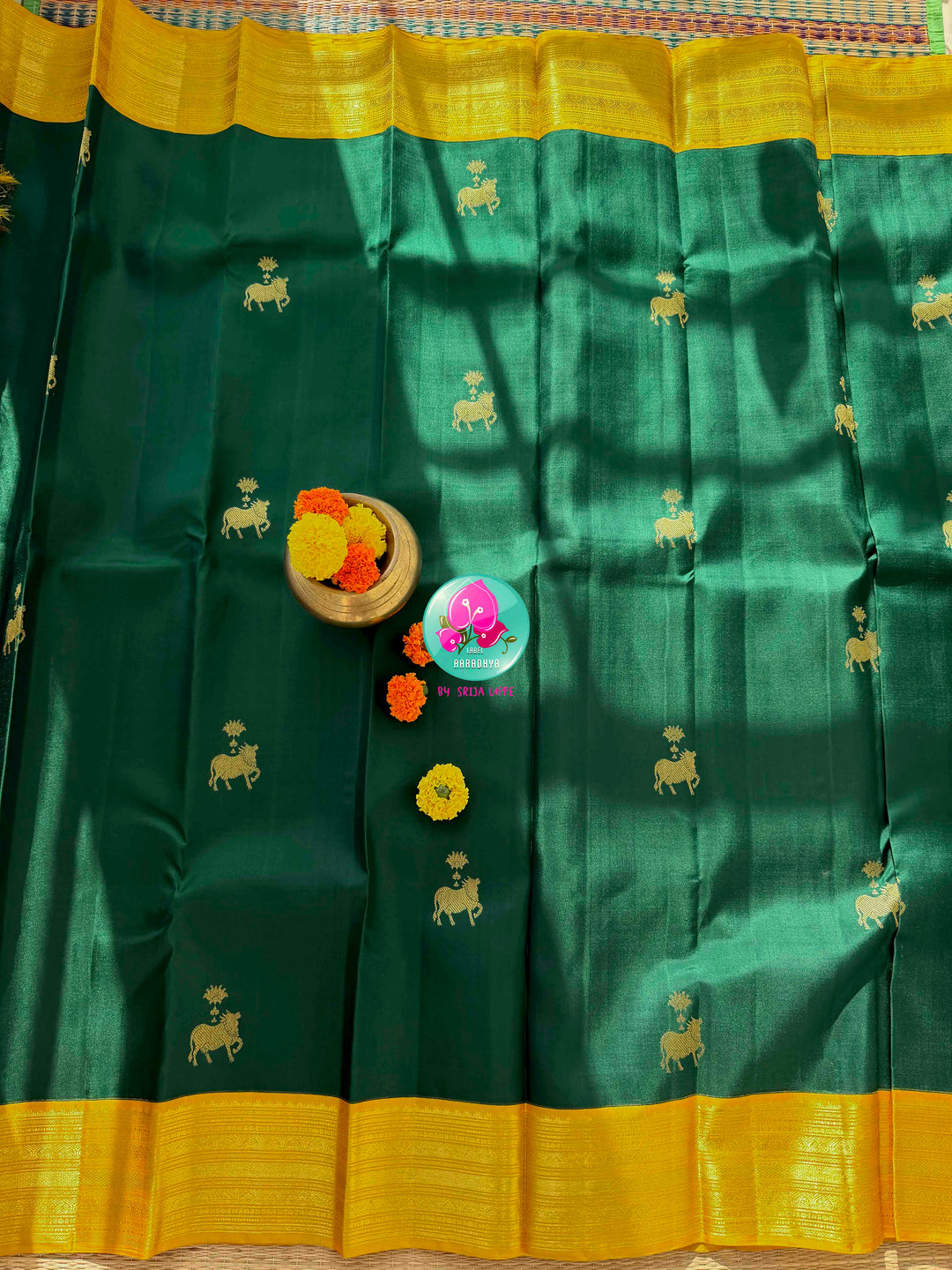 Sacred Pichwai Reverence: Bottle Green Pure Kanjeevaram Saree with Mustard Korvai Border & Kamadhenu Art