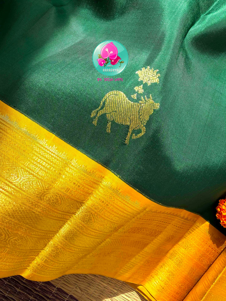 Sacred Pichwai Reverence: Bottle Green Pure Kanjeevaram Saree with Mustard Korvai Border & Kamadhenu Art