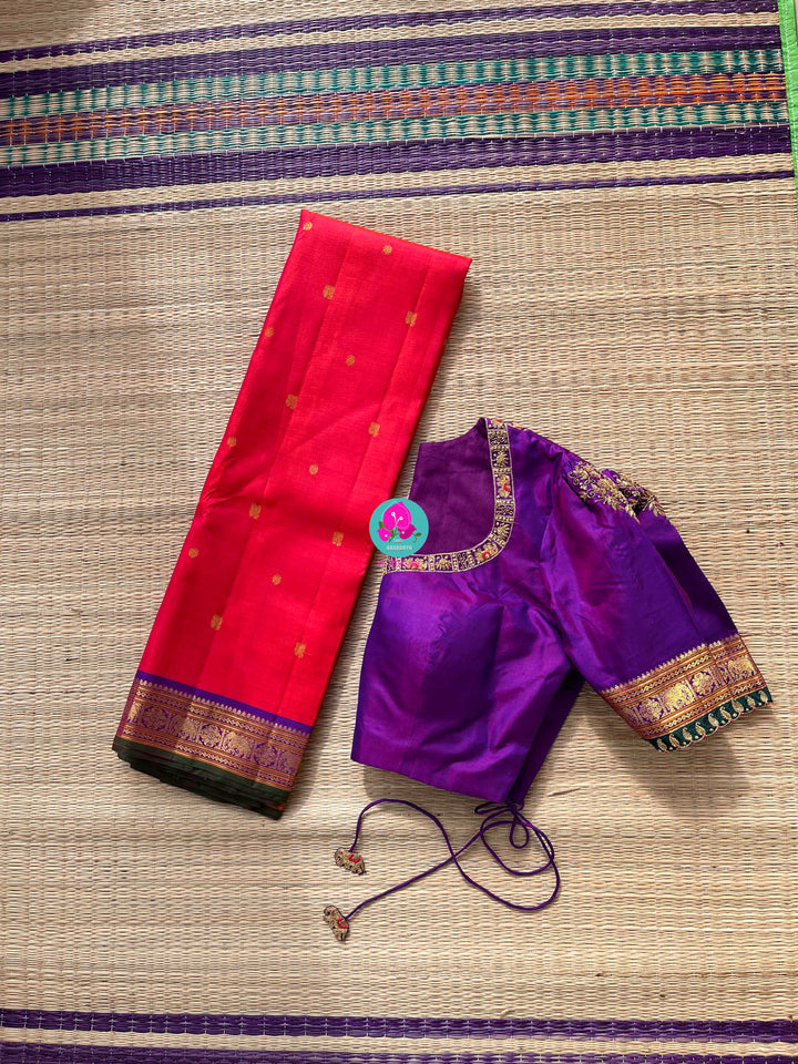Pinkish shade of red with deep purple border Kanchipuram silk Saree paired with hand embroidered blouse