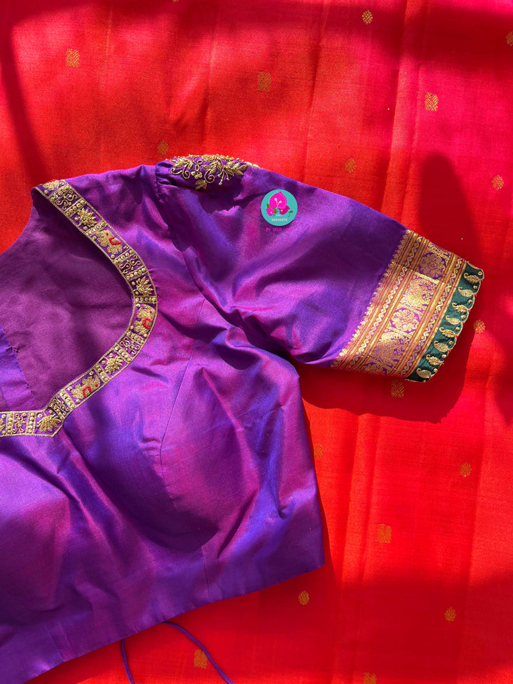 Pinkish shade of red with deep purple border Kanchipuram silk Saree paired with hand embroidered blouse