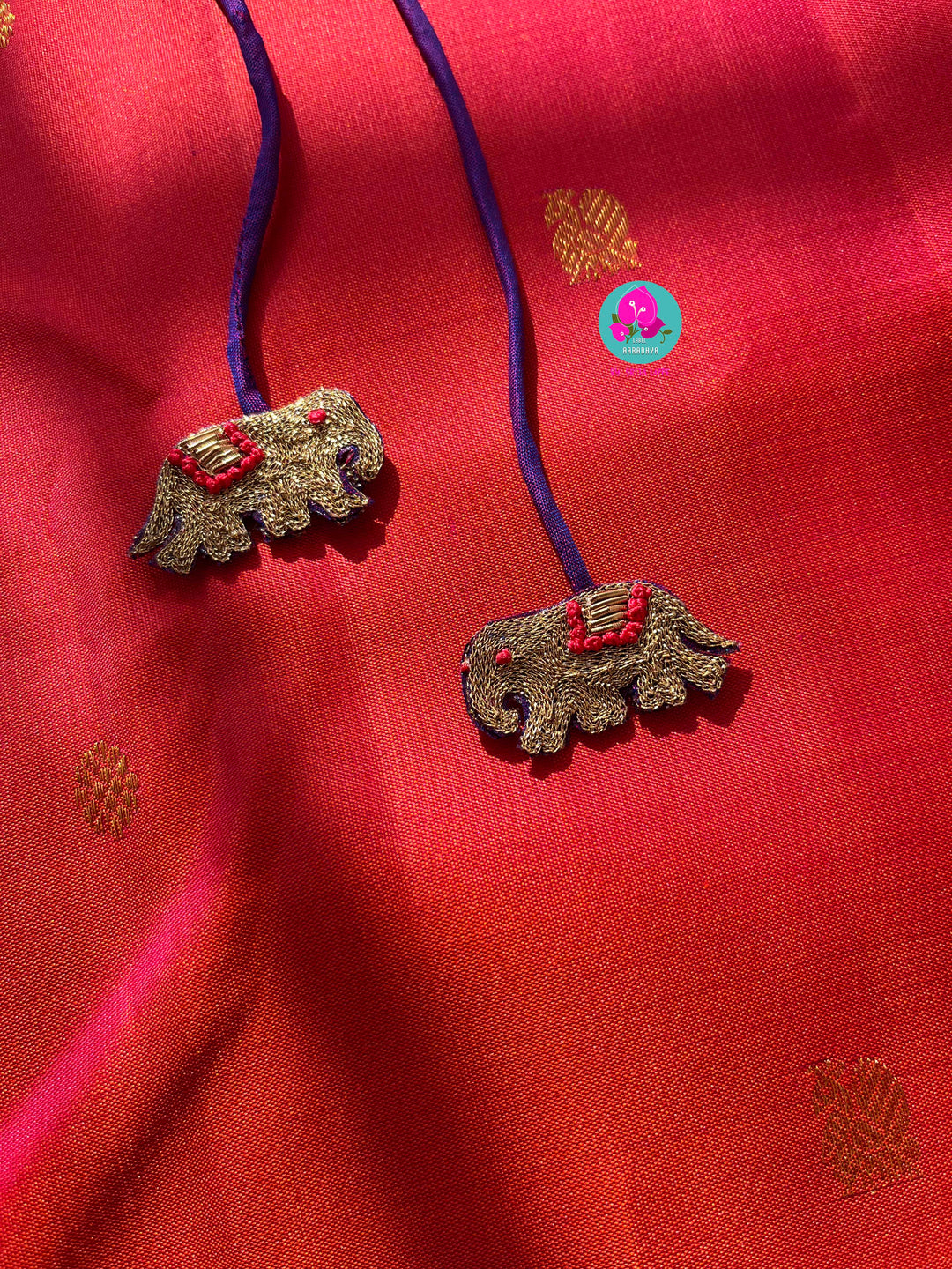Pinkish shade of red with deep purple border Kanchipuram silk Saree paired with hand embroidered blouse
