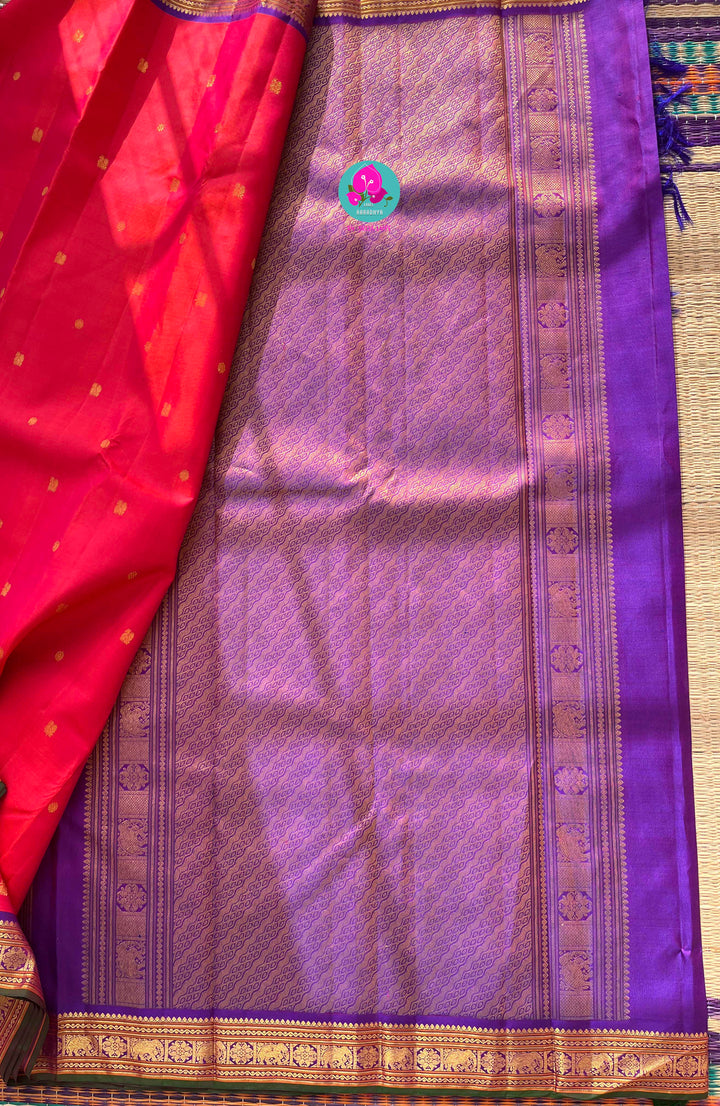Pinkish shade of red with deep purple border Kanchipuram silk Saree paired with hand embroidered blouse