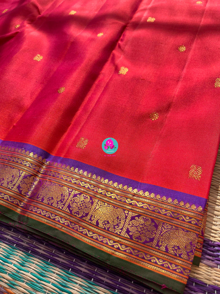 Pinkish shade of red with deep purple border Kanchipuram silk Saree paired with hand embroidered blouse