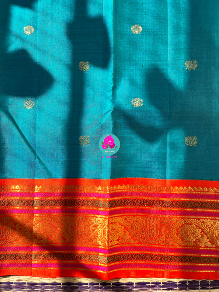 Starlit Symphony: Regal Dark Blue Kanjivaram Saree Paired with a Sunrise Orange Artisan Blouse