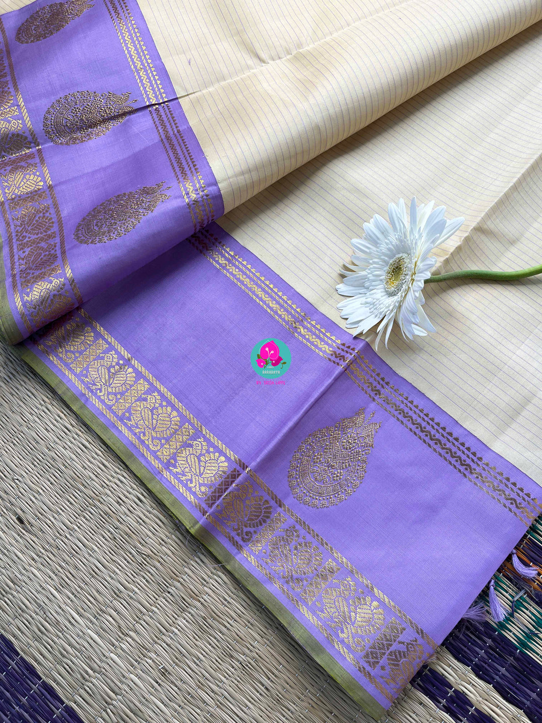 Creamish offwhite Kanchipattu saree with a contrast green and lavender combination