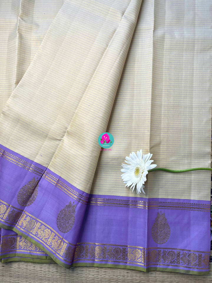 Creamish offwhite Kanchipattu saree with a contrast green and lavender combination