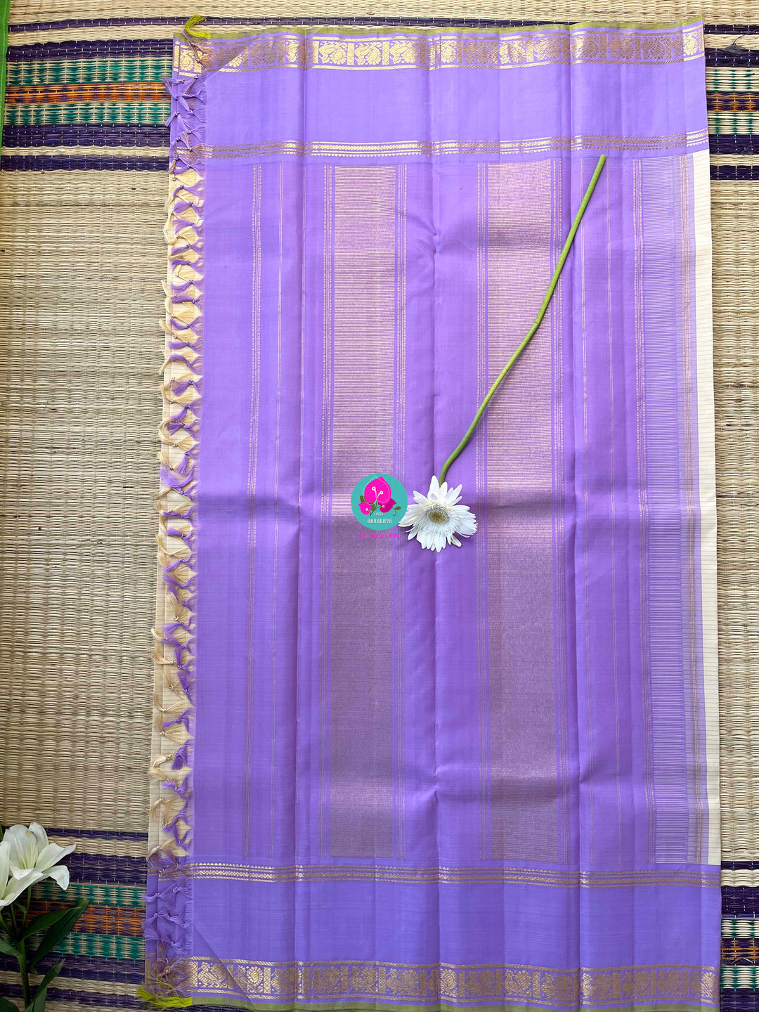 Creamish offwhite Kanchipattu saree with a contrast green and lavender combination